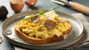 Creamy scrambled eggs topped with black truffle shavings, served on toasted sourdough with parmesan and chive garnish.
